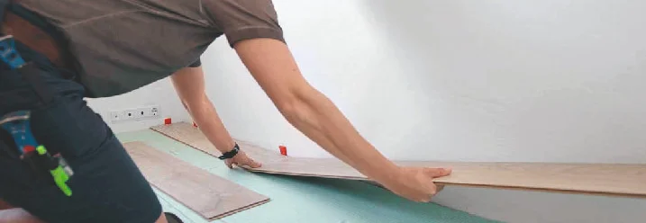 Person verlegt Laminat auf Trittschalldämmung